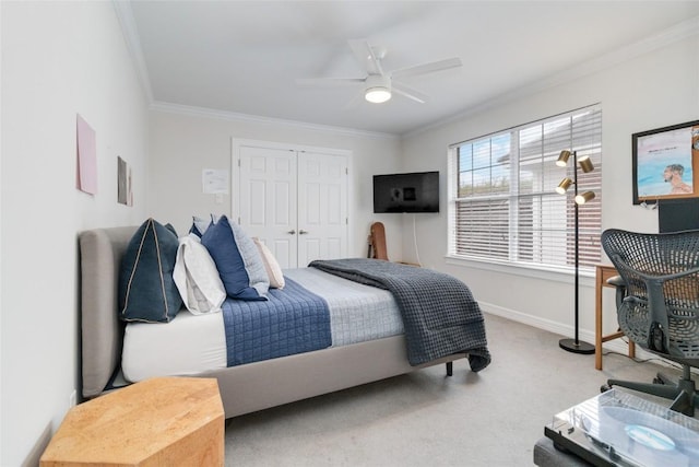 bedroom with carpet, a closet, ceiling fan, and ornamental molding