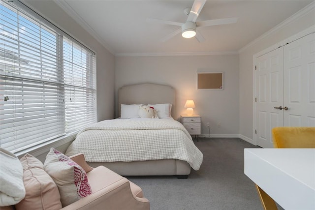 bedroom with ceiling fan, dark carpet, ornamental molding, and a closet