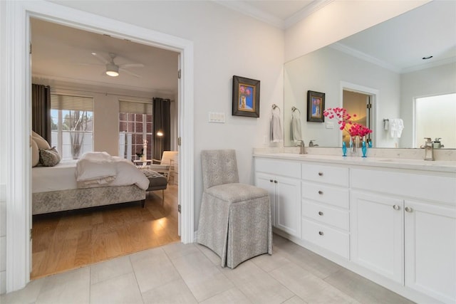 bathroom featuring ceiling fan, hardwood / wood-style floors, vanity, and ornamental molding