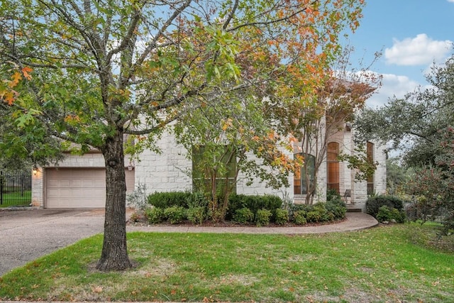 obstructed view of property featuring a front yard and a garage