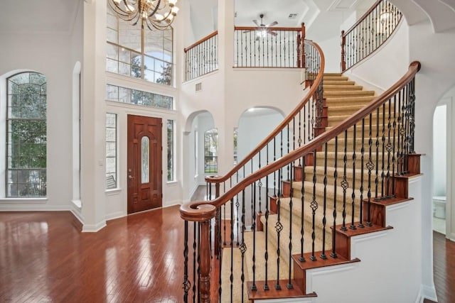 foyer entrance featuring hardwood / wood-style floors, a towering ceiling, and a wealth of natural light