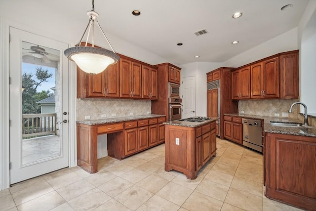 kitchen featuring hanging light fixtures, sink, decorative backsplash, appliances with stainless steel finishes, and a kitchen island