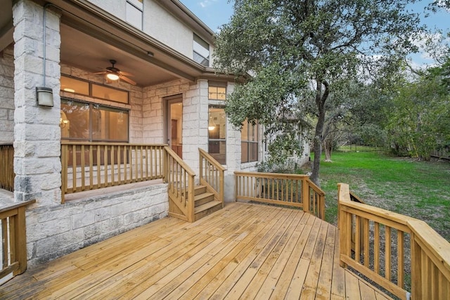 wooden deck with ceiling fan and a yard