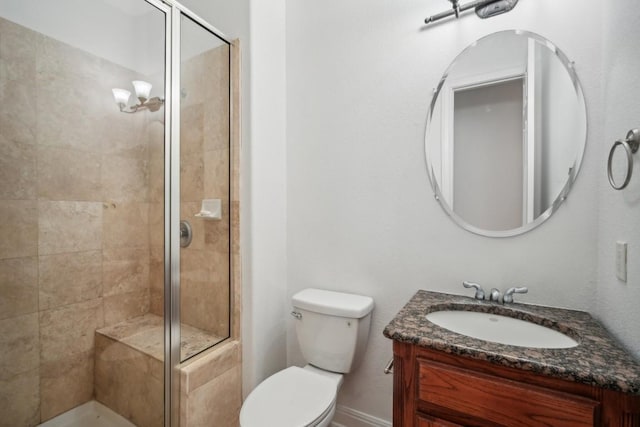 bathroom with a shower with door, vanity, and toilet