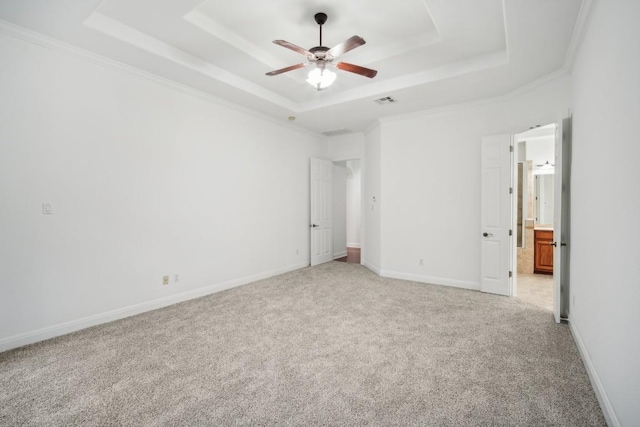 unfurnished bedroom featuring ceiling fan, a raised ceiling, light colored carpet, and ornamental molding