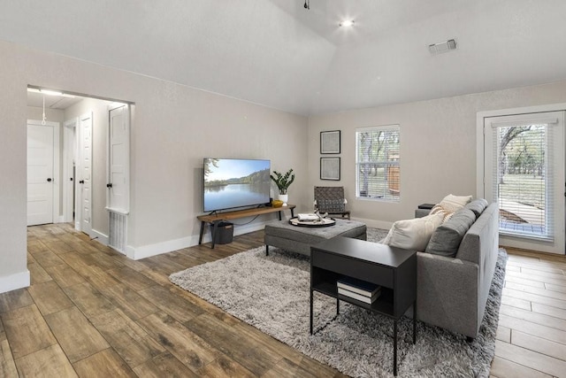 living room featuring wood-type flooring and lofted ceiling