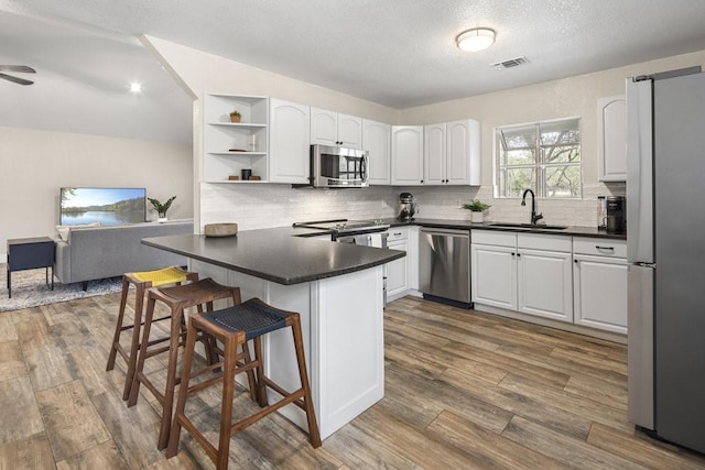 kitchen featuring white cabinets, sink, kitchen peninsula, and stainless steel appliances