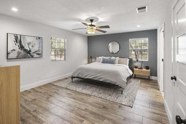 bedroom featuring multiple windows, ceiling fan, and hardwood / wood-style floors