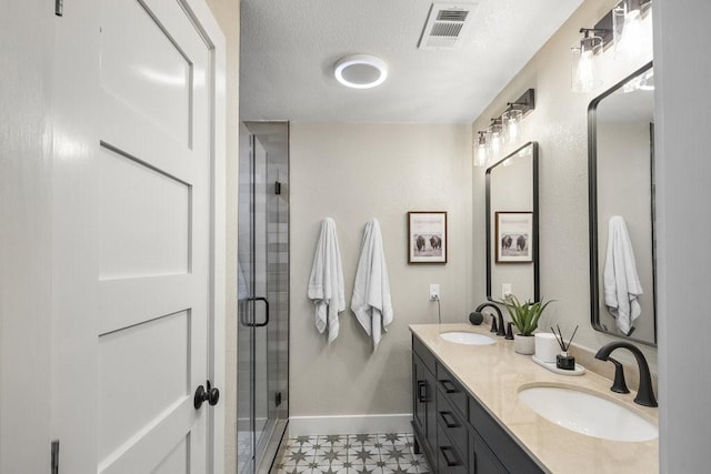 bathroom featuring tile patterned flooring, vanity, a textured ceiling, and an enclosed shower