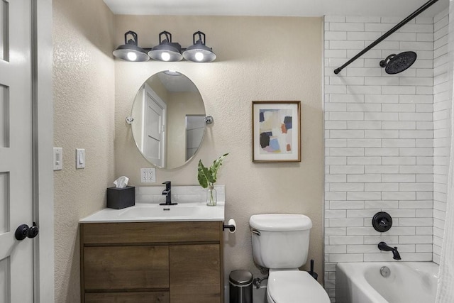 full bathroom featuring vanity, tiled shower / bath combo, and toilet