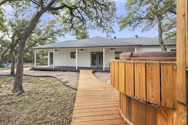 back of property featuring ceiling fan, french doors, a hot tub, and a deck