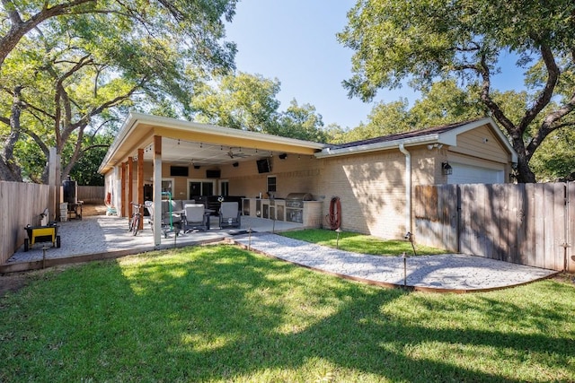 back of house with a lawn, a patio, and exterior kitchen