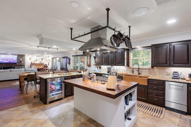 kitchen featuring butcher block counters, a kitchen island, wine cooler, and island exhaust hood