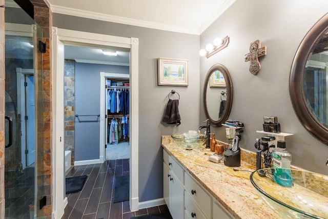 bathroom featuring vanity, ornamental molding, and tiled shower