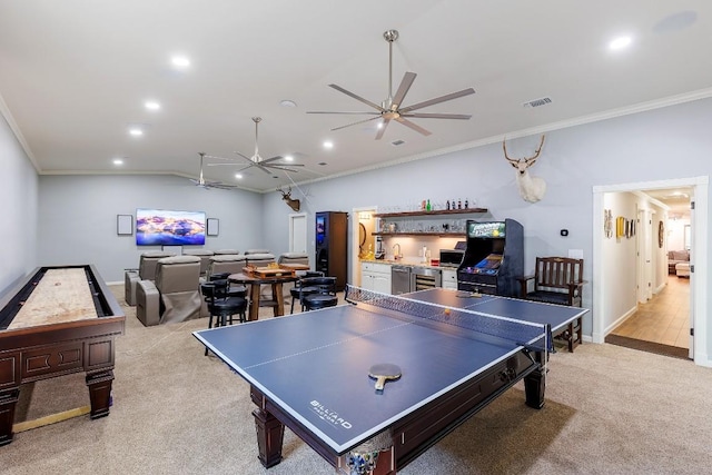 rec room with ceiling fan, light colored carpet, ornamental molding, and bar area