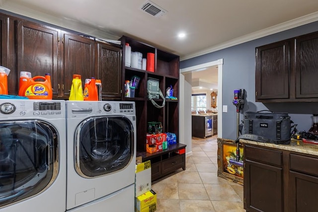 laundry area with cabinets, light tile patterned floors, washer and clothes dryer, and crown molding