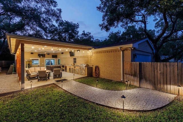 back house at dusk with area for grilling, outdoor lounge area, and a patio