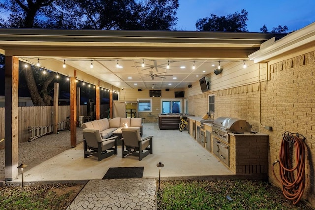 patio terrace at dusk featuring an outdoor living space, a grill, exterior kitchen, and ceiling fan