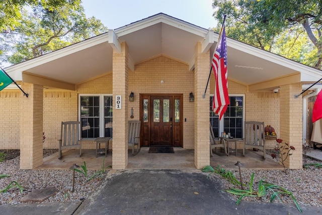 view of exterior entry featuring french doors and a patio