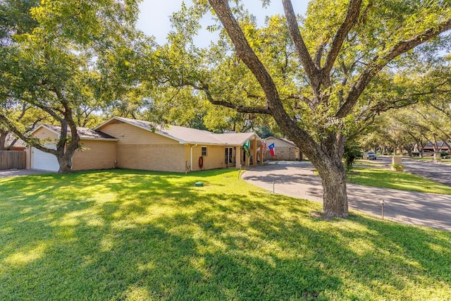 ranch-style home featuring a garage and a front yard