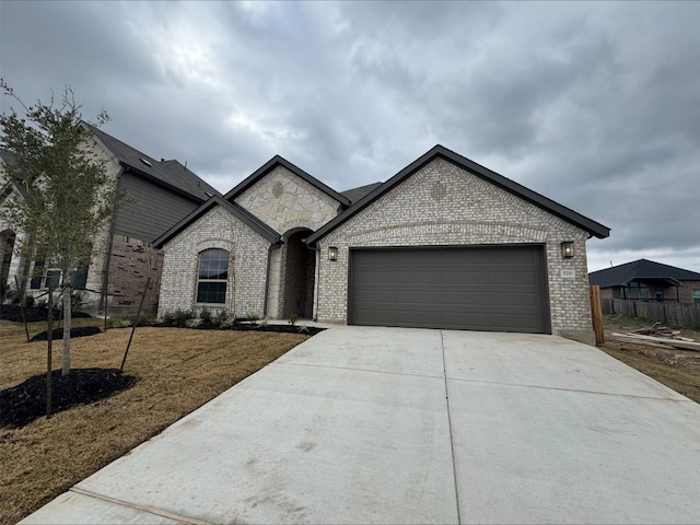 french provincial home with a garage and a front yard