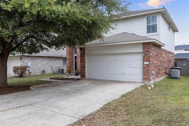 view of front of house with a yard, cooling unit, and a garage