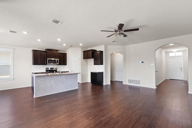 unfurnished living room with dark hardwood / wood-style floors, ceiling fan, and sink