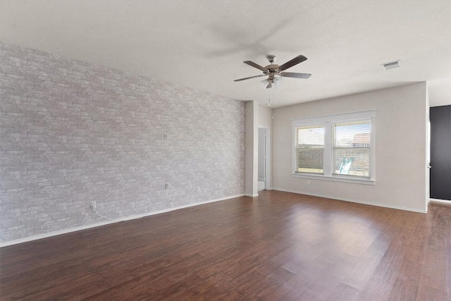 spare room featuring ceiling fan and dark wood-type flooring