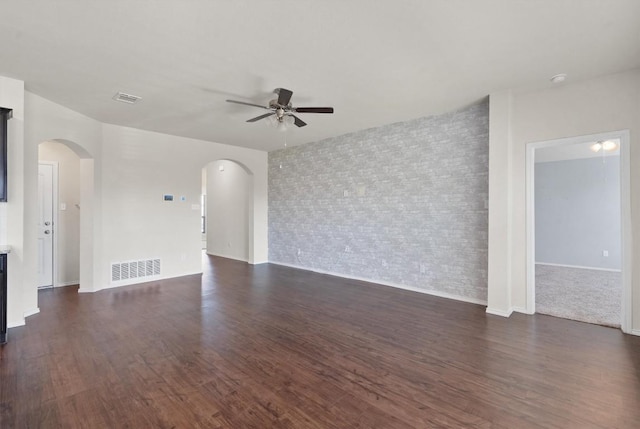 unfurnished living room with ceiling fan and dark hardwood / wood-style flooring