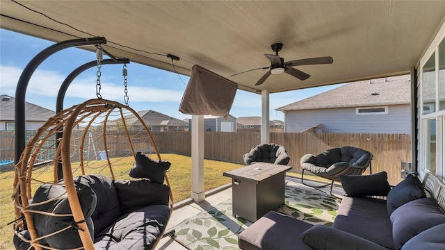 view of patio / terrace featuring ceiling fan and an outdoor living space with a fire pit