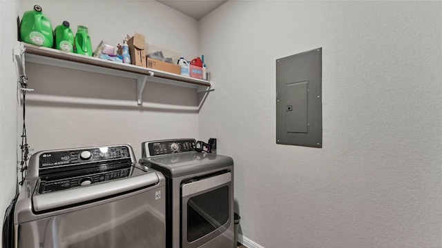 clothes washing area with electric panel and washing machine and dryer