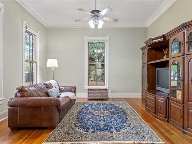 living room featuring crown molding, ceiling fan, and light hardwood / wood-style floors