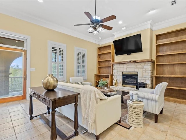 living room featuring built in shelves, ceiling fan, a stone fireplace, light tile patterned flooring, and ornamental molding