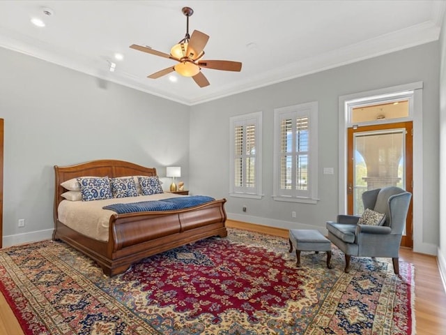 bedroom with hardwood / wood-style flooring, ceiling fan, and ornamental molding