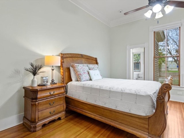 bedroom with hardwood / wood-style flooring, ceiling fan, and ornamental molding