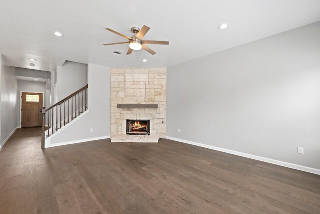 unfurnished living room with a fireplace, dark hardwood / wood-style flooring, and ceiling fan