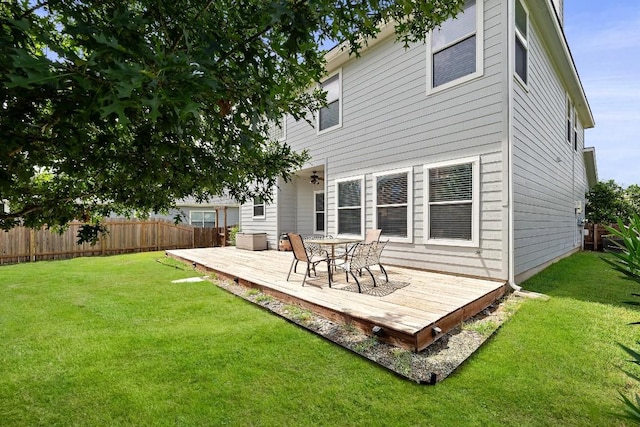 rear view of property featuring a deck and a yard