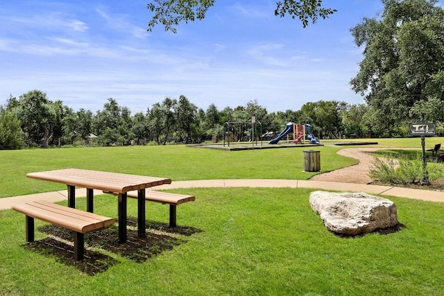 view of home's community with a playground and a lawn