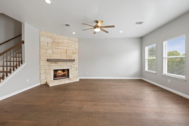 unfurnished living room with ceiling fan, a fireplace, and dark hardwood / wood-style floors