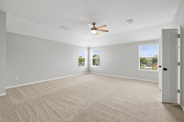 spare room featuring ceiling fan, plenty of natural light, and light colored carpet