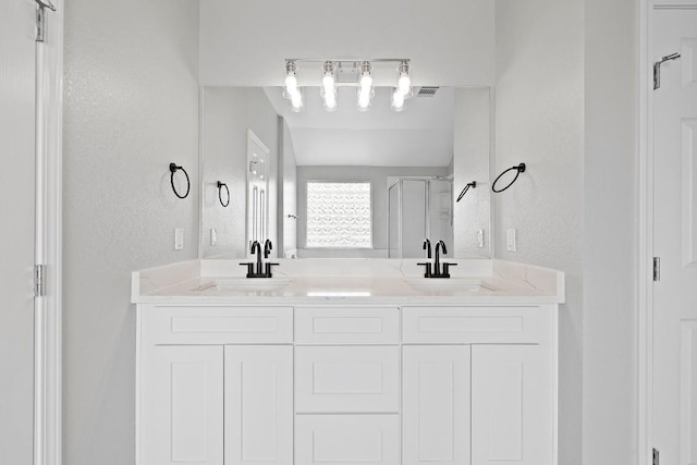 bathroom featuring vanity and a shower with shower door