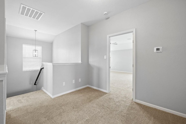 carpeted spare room with vaulted ceiling