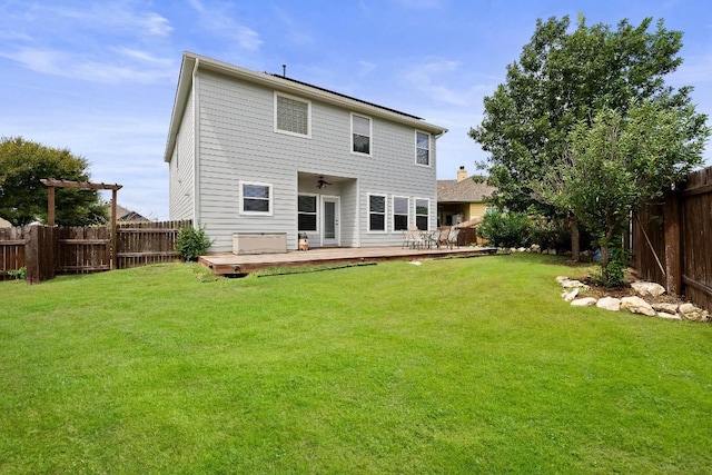 rear view of property with a deck and a yard