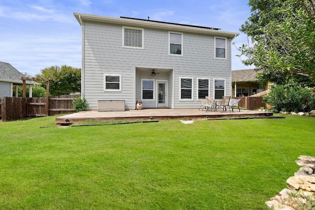 back of property featuring a lawn and a wooden deck