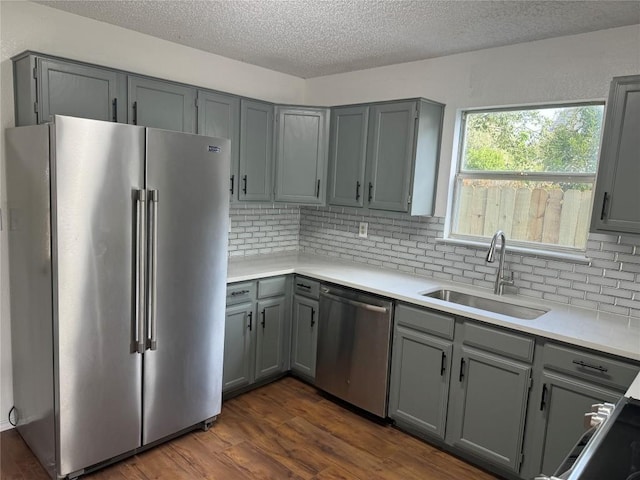 kitchen featuring dark wood-type flooring, sink, gray cabinetry, and stainless steel appliances