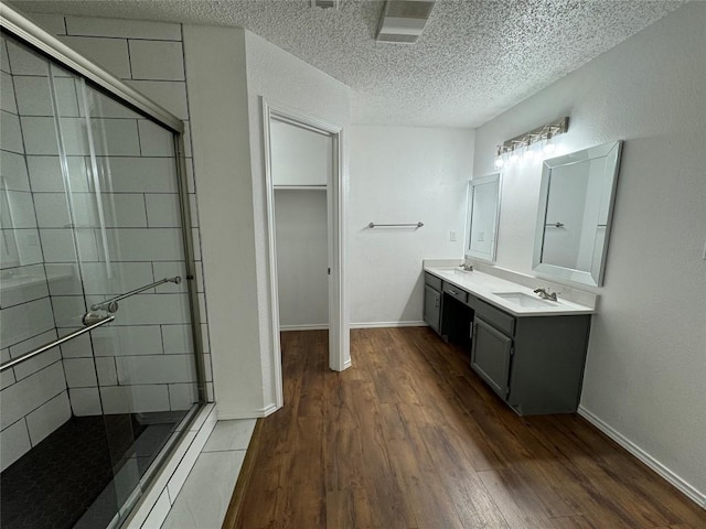 bathroom featuring vanity, a textured ceiling, hardwood / wood-style flooring, and an enclosed shower