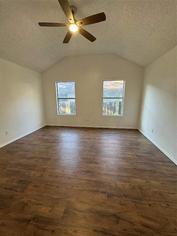 unfurnished room featuring plenty of natural light, lofted ceiling, and a textured ceiling