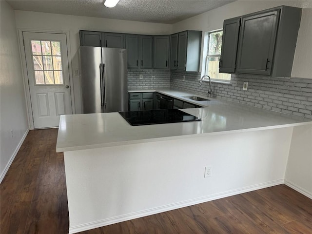 kitchen featuring kitchen peninsula, sink, black appliances, and dark hardwood / wood-style flooring