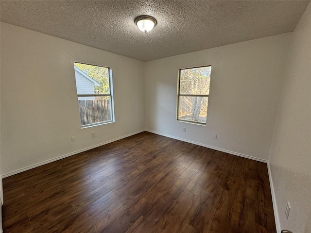 empty room featuring dark hardwood / wood-style flooring and a textured ceiling