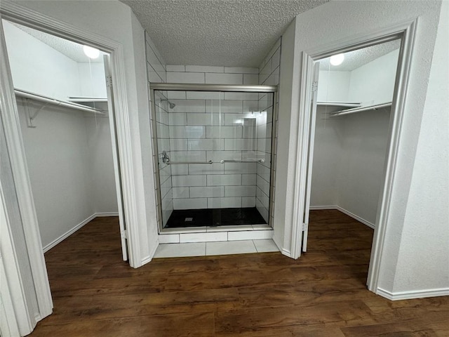 bathroom with wood-type flooring, a textured ceiling, and an enclosed shower